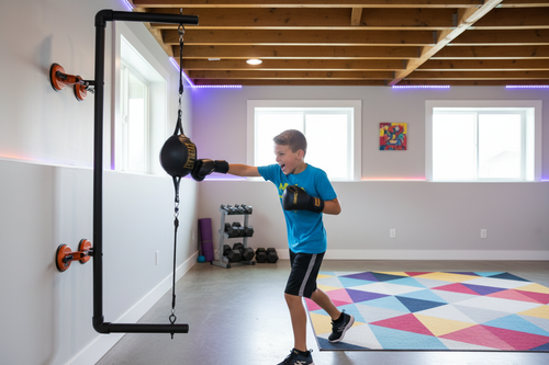 Kid punching the ThunderBox wall-mounted boxing system at home